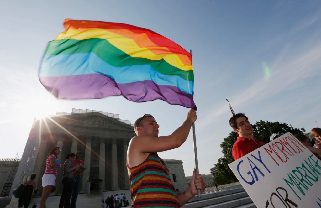Gay rights supporter waving a rainbow flag outside the U.S. Supreme Court building in Washington following its ruling expanding gay rights, June 26, 2013. (Win McNamee/Getty Images)