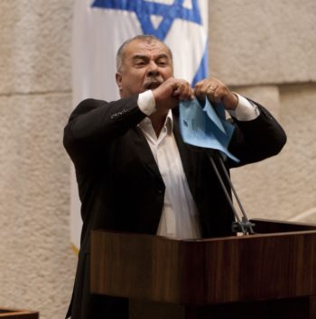 Mohammad Barakeh of the Hadash party tearing the Bedouin settlement bill while speaking in the Knesset, June 24, 2013. (Flash90)