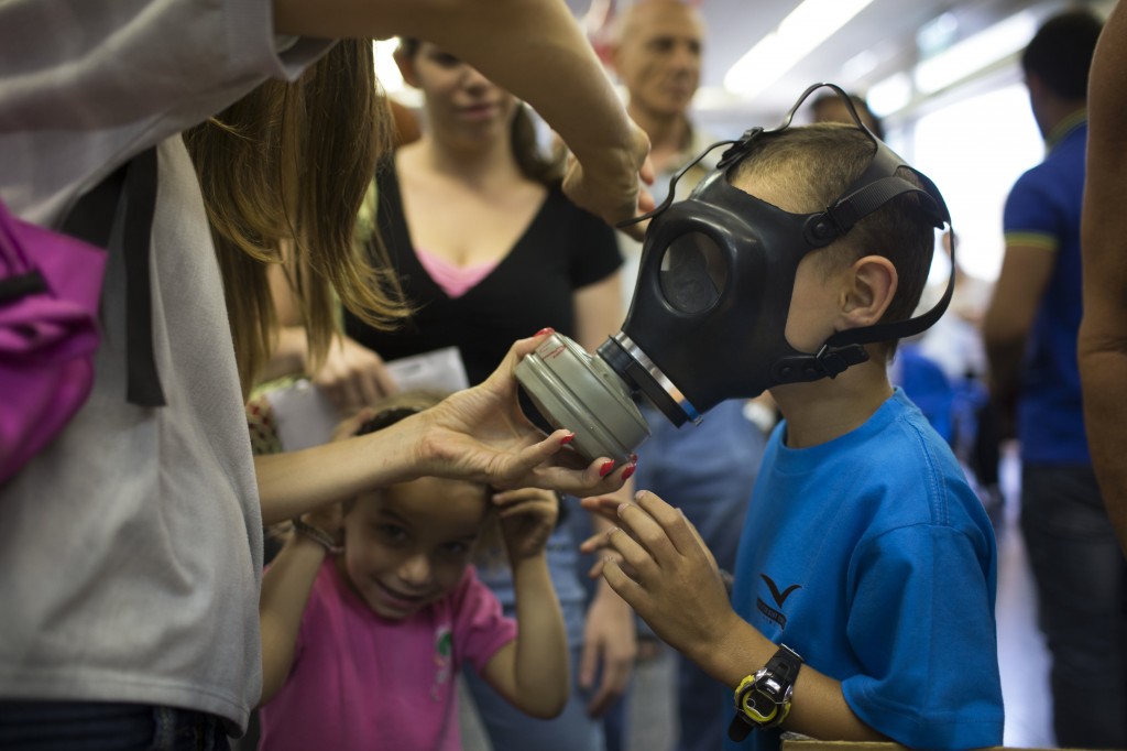 Israeli child trying on a gas mask at a distribution center in Tel Aviv, Aug. 26. (Uriel Sinai/Getty Images)