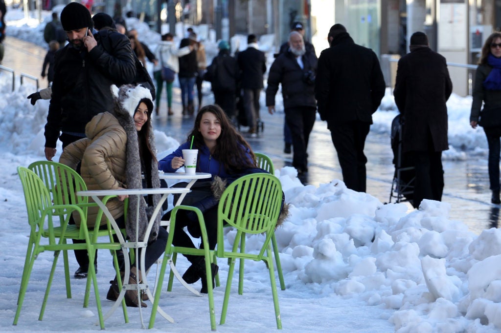A cafe table is set up amid the snow on Jerusalem's Jaffa Road on Dec. 15, 2013. (Hadas Parush/Flash 90)