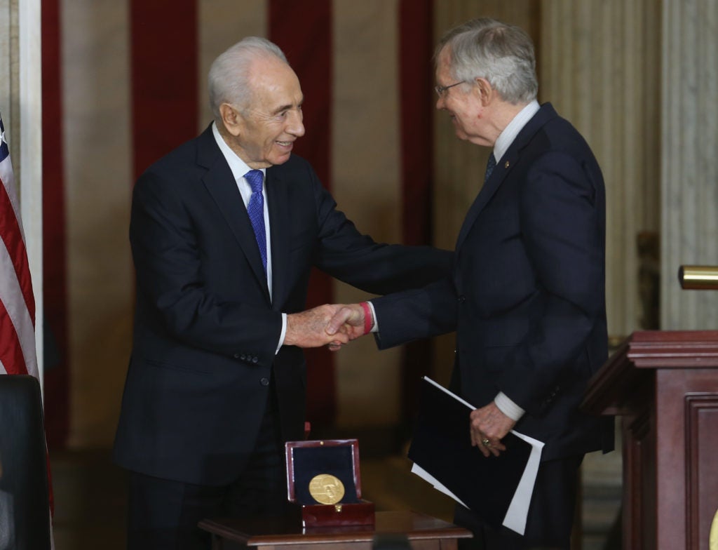 Israeli President Shimon Peres (L) shakes hands with Senate Majority Leader Harry Reid (D-NV) during a Congressional Gold Medal ceremony at the U.S. Capitol, June 26, 2014 in Washington, D.C. (Mark Wilson/Getty Images)
