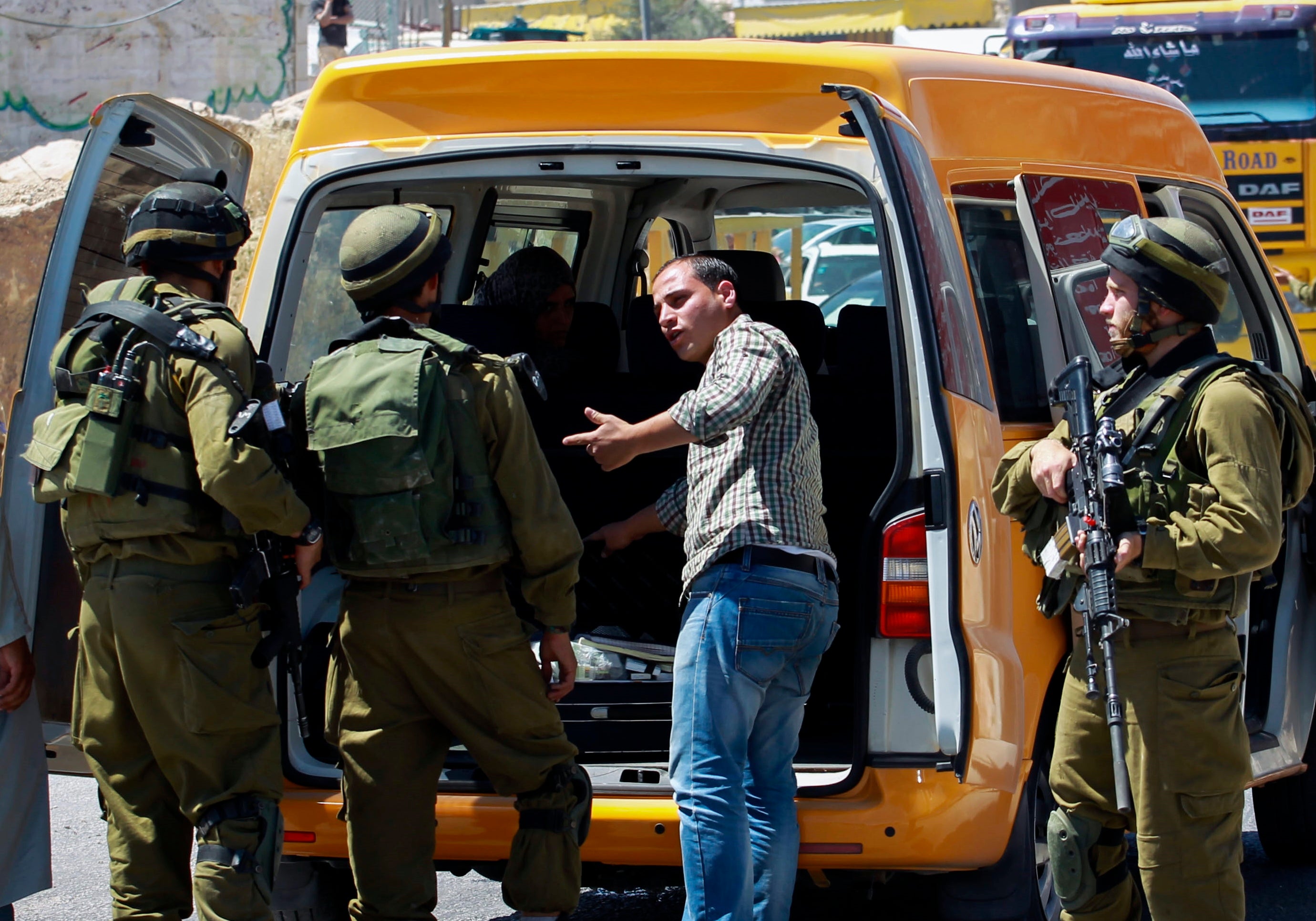 Israeli soldiers searching Palestinians at a checkpoint set up at the entrance to the industrial zone of Hebron in the effort to find three kidnapped Israeli teenagers, June 15, 2014. (Hadas Parush/Flash 90)