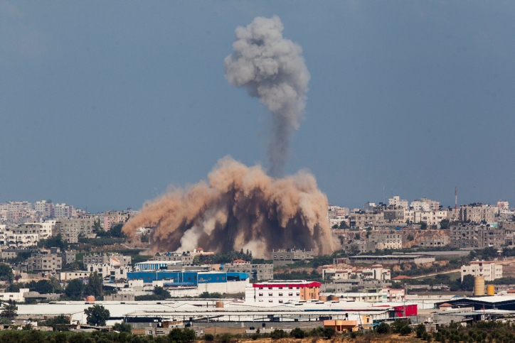 Smoke and debris rise from a site in Gaza after an Israeli airstrike, July 9, 2014. (Yonatan Sindel/Flash90)