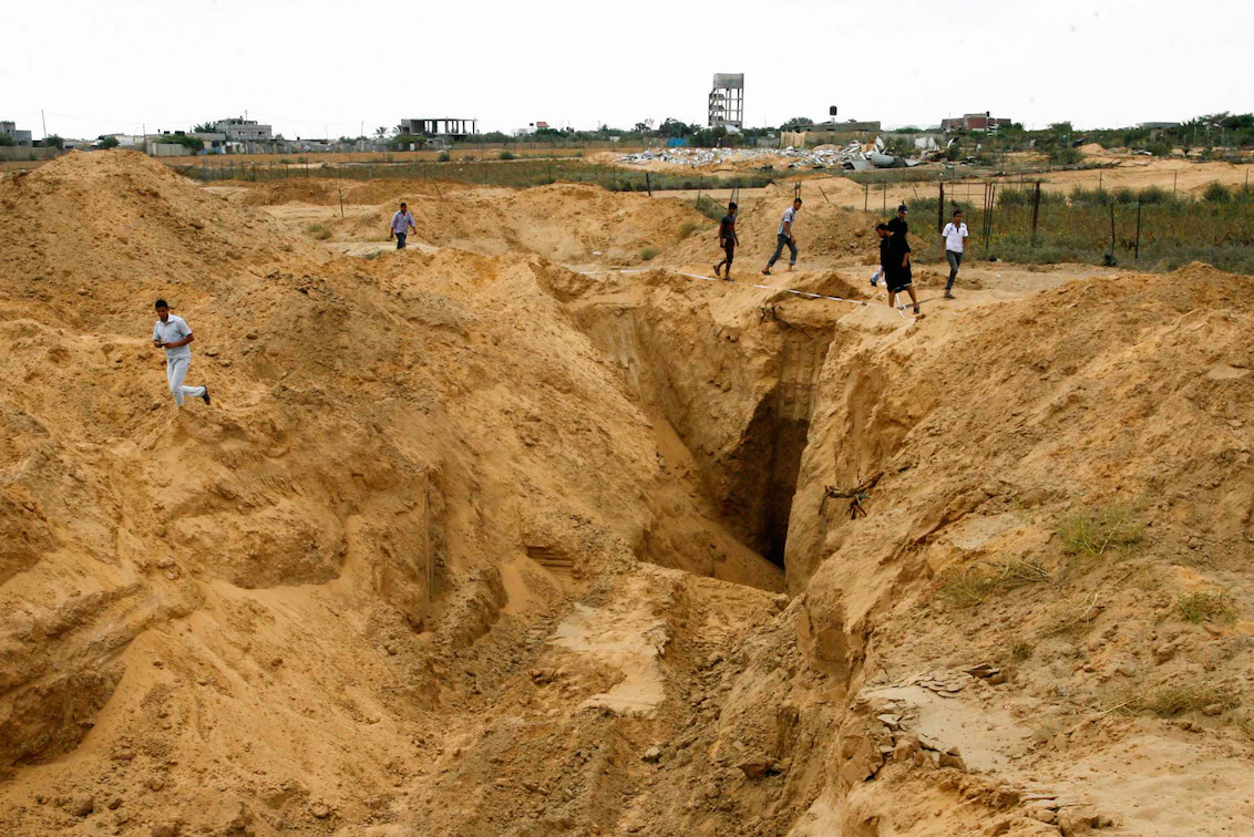 Palestinian men look at what used to be a tunnel leading from the Gaza Strip into Israel, in the area of Rafah in the southern Gaza Strip, on Aug.  5,  2014, after a 72-hour truce agreed by Israel and Hamas went into effect. (Abed Rahim Khatib/Flash90)