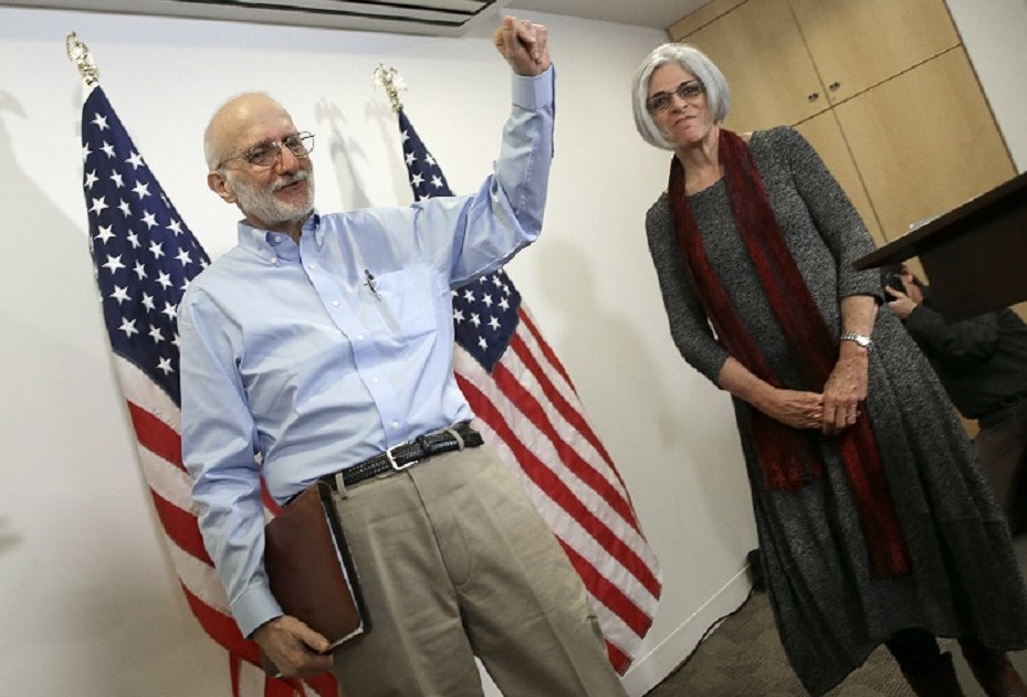Alan Gross, recently released by Cuban authorities, waves after concluding his remarks with his wife Judy (R) at a press conference at his lawyer's office shortly after arriving in the United States, Dec. 17, 2014 in Washington, DC. (Photo by Win McNamee/Getty Images)