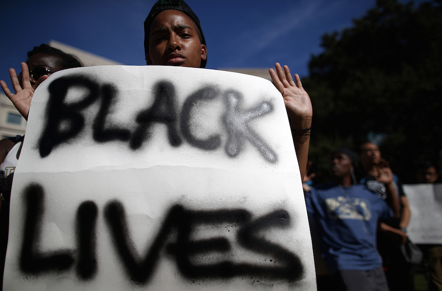 A demonstrator holding a sign during a moment of silence for victims of police brutality, in Oakland, California, Aug. 14, 2014. (Justin Sullivan/Getty Images)