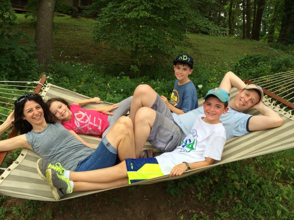 Liz and Dan Spevack with children Ayelet, Noam and Eytan, on a hammock at Ramah Berkshires. The Spevacks, who met at Ramah Berkshires, are among the approximately 700 couples who met at Ramah camps. Dan Spevack's parents also met at Ramah Berkshires, and all three children attend Ramah camps. (Courtesy of Liz Spevack)