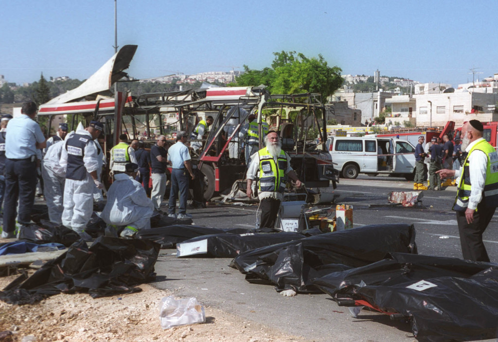 Israeli rescue workers tend to victims' bodies from the scene of a Palestinian suicide bombing on a passenger bus in Jerusalem June 18, 2002. (Yossi Zamir/Flash 90)