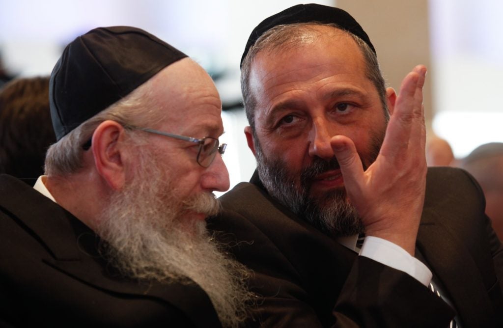 Shas party leader Aryeh Deri, right, and Yaakov Litzman, head of United Torah Judaism, at the opening session of the 20th Israeli parliament, March 31, 2015. (Nati Shohat/Flash90)