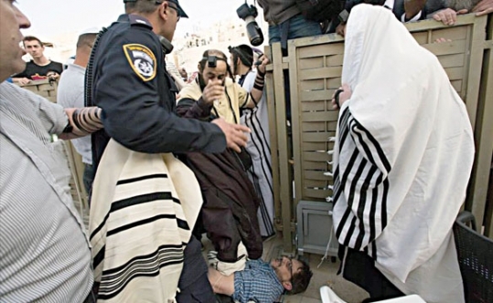 Alden Solovy, on the ground, being stomped on by another worshipper at the Western Wall. 