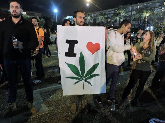 Demonstrator at a Tel Aviv rally pushing for the legalization of marijuana in Israel holding a sign displaying his stance, May 2, 2015. (Ben Sales) 