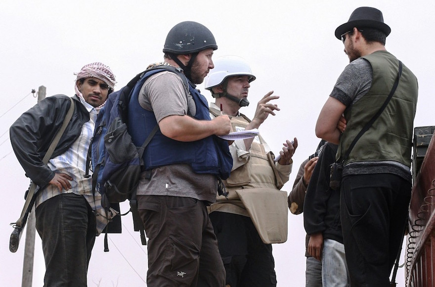 In this handout image made available by the photographer, American journalist Steven Sotloff, center with black helmet, talks to Libyan rebels on the Al Dafniya front line, about 15 miles from Misrata, Libya, June 2, 2011. Sotloff was beheaded in September 2014 nearly a year after being kidnapped in Syria. (Etienne de Malglaive via Getty Images)
