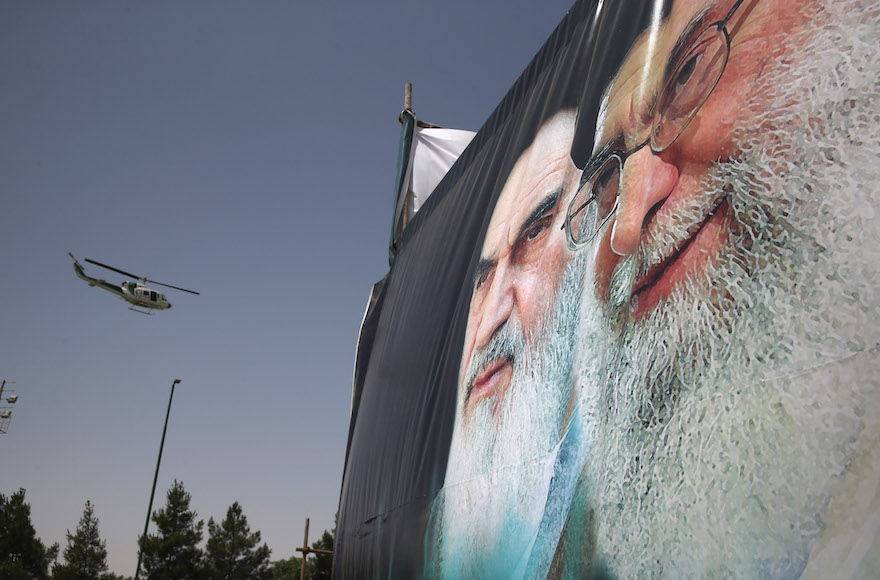 An Iranian police helicopter passes by portraits of Iran's supreme leader Ayatollah Ali Khamenei, right, and the former Ayatollah Khomeini, in Tehran, Iran, June 4, 2015. (John Moore/Getty Images)
