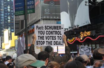 A protestor holds a sign urging Senator Chuck Schumer to vote against the Iran deal at the "Stop Iran Now" rally in Times Square on July 22, 2015. (Gabe Friedman/JTA)