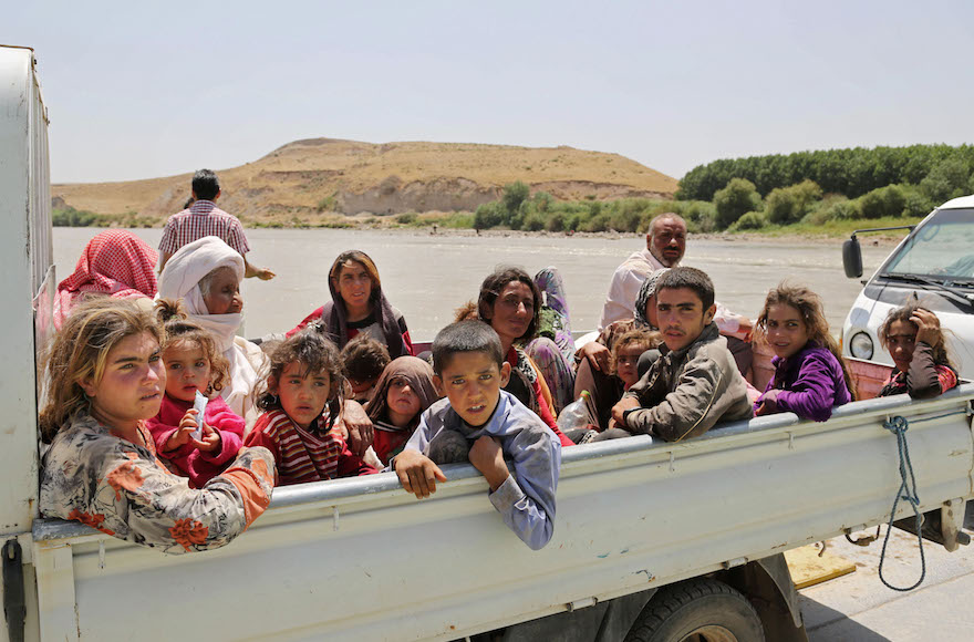 Displaced Iraqis from the Yazidi community cross the Iraq-Syria border, Aug. 10, 2014. (Khalid Mohammed/AP Images)