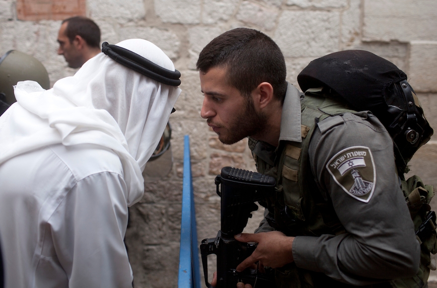 An Israeli border policeman speaking to a Palestinian man next to a stabbing scene in Jerusalem's Old City, October 7, 2015. (Lior Mizrahi/Getty Images)