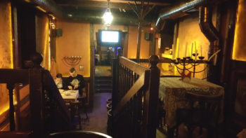 Patrons reading the price-free menu at Pid Zolotoju Rozoju, the "Jewish" restaurant adjacent to the remnants of the Golden Rose Synagogue. (Cnaan Liphshiz)