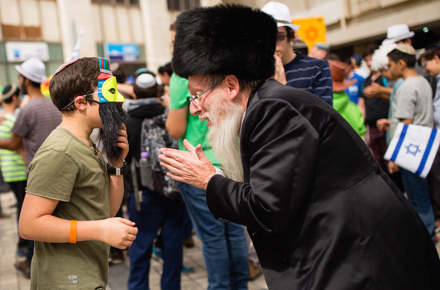 An ultra orthodox jewish man talks to a young Jewish Israeli in central Jerusalem, March 13, 2016. (Corinna Kern/Flash90)