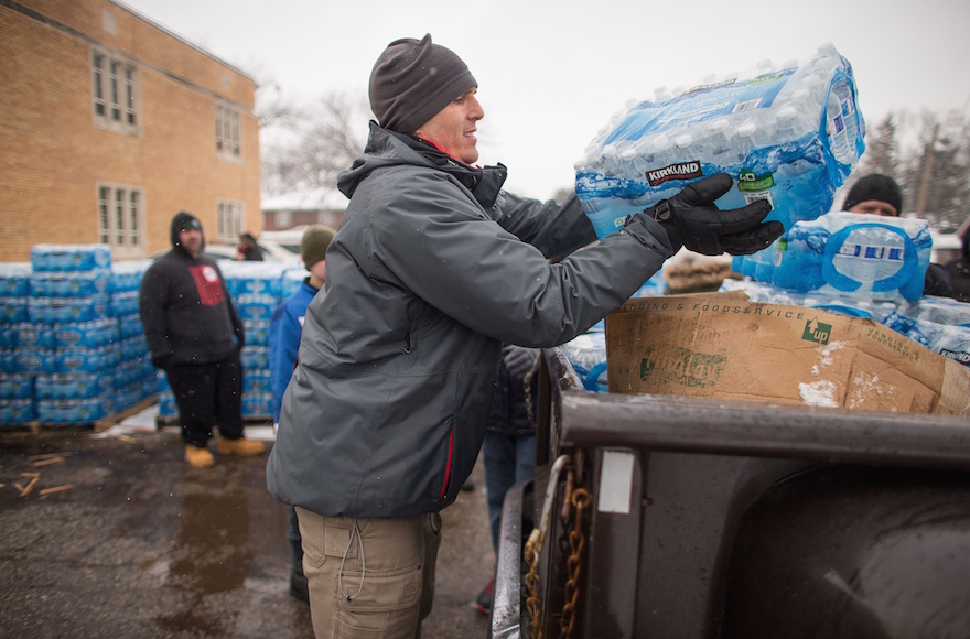 Volunteers loading cases of free water into waiting vehicles at a water distribution center in Flint, Mich., March 5, 2016. (GEOFF ROBINS/AFP/Getty Images)
