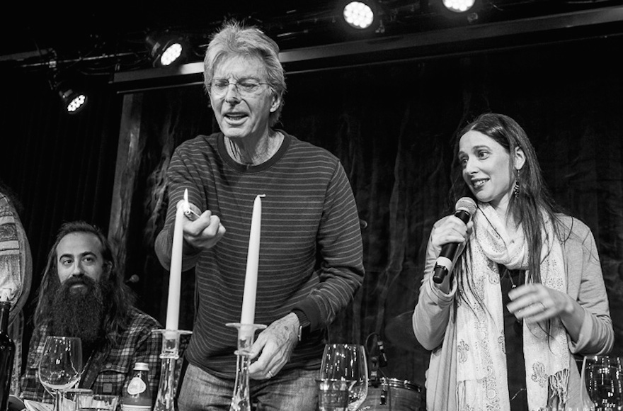 Phil Lesh lights the candles as Jeannette Ferber, a cantorial soloist at Berkeley's Renewal congregation Chochmat HaLev, sings the blessing, and guitarist Ross James looks on. (© Bob Minkin Photography / www.minkinphotography.com)
