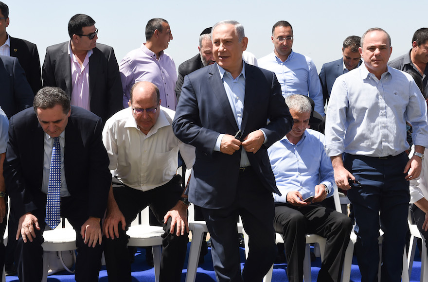 Israeli Prime Minister Benjamin Netanyahu posing for a group photograph with his government at a special weekly Cabinet meeting held in Israel's Golan Heights, April 17, 2016. (Effi Sharir/Pool)
