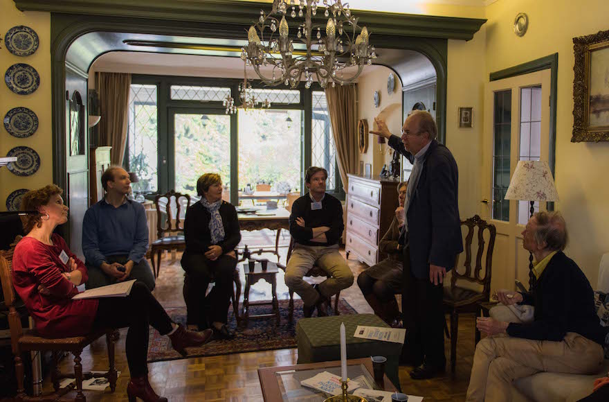 Kees van den Heuvel, standing, talking to guests about the Jewish family that once lived in what is now his home in the town of Vught, the Netherlands, April 30, 2016. (Cnaan Liphshiz)