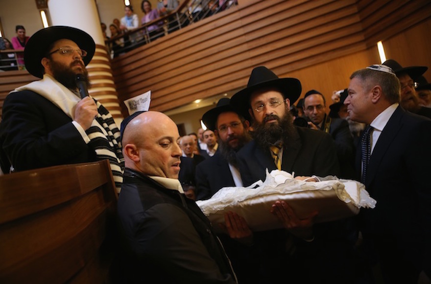 An infant being carried before his circumcision at an Orthodox synagogue in Berlin in 2013. (Sean Gallup/Getty Images)