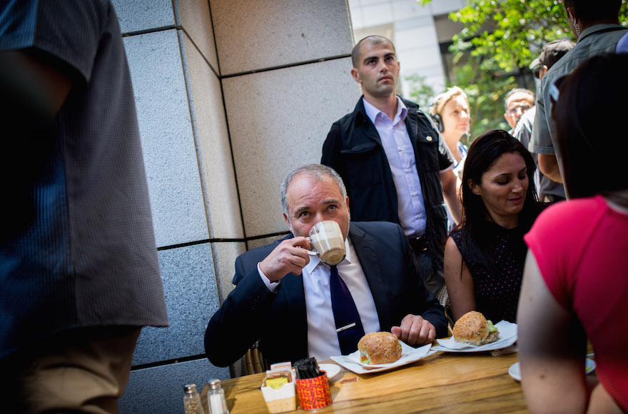 Defense Minister Avigdor Liberman drinking coffee at Sarona Market in Tel Aviv, a day after a deadly attack at the pedestrian mall, June 9, 2016. (Miriam Alster/Flash90)
