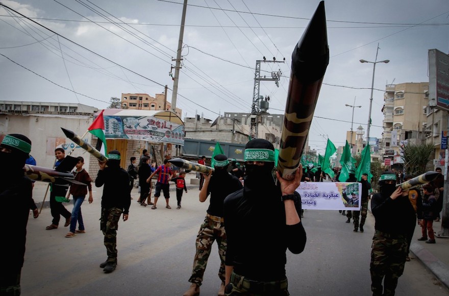 Masked members from the Ezzedine al-Qassam carrying a model of a rocket during a rally to commemorate the 27th anniversary of Hamas' creation in Gaza, Dec. 12, 2014. (Abed Rahim Khatib/Flash90)