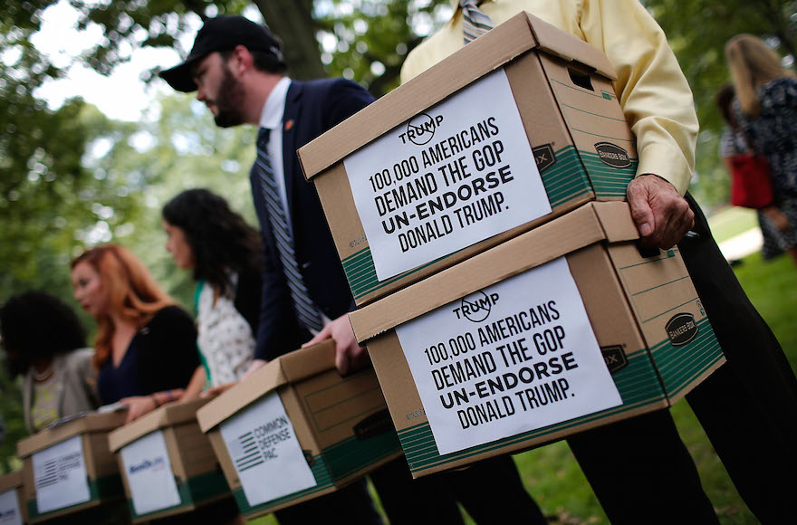 Former members of the U.S. military carrying boxes with more than 100,000 signatures requesting that Sen. John McCain and other Republican leaders withdraw their endorsement of Republican presidential candidate Donald Trump following a press conference in Washington, D.C., Aug. 4, 2016. (Win McNamee/Getty Images)