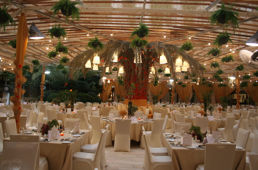 The sukkah designed by Studio Ya Ya in 2010 for the Inbal Jerusalem Hotel employed a massive, palm tree centerpiece threaded with tiny red flowers. (Courtesy of Yarok Yarok Events Design)