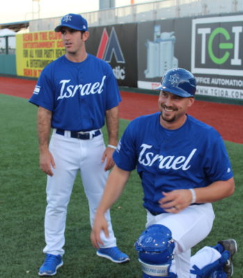 Catcher Ryan Lavarnway, who socked three singles, enjoys a moment during pregame warmups with Israel’s bullpen coach Alon Leichman, in Brooklyn, New York, Sept. 22, 2016. (Hillel Kuttler)