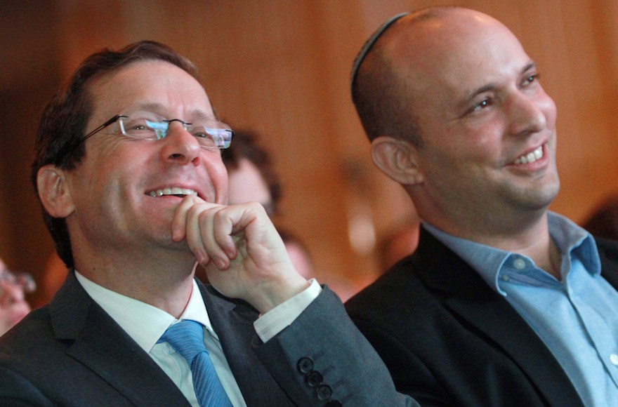 Israeli Labor Party leader Isaac Herzog, left, and head of the Jewish Home party Naftali Bennett listening during a debate on the economy in Tel Aviv, March 11, 2015. (Gil Cohen Magen/AFP/Getty Images)