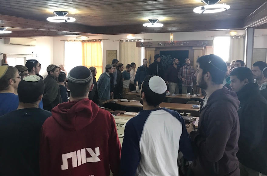 Young men dancing and singing in the synagogue in Amona, the West Bank, Dec. 13, 2016. (Andrew Tobin)