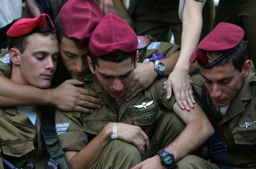 Israeli paratroopers comfort each other as they grieve at the grave of their friend First Sergeant Michael Levin during his funeral at the Mount Herzl military cemetery in Jerusalem, Aug. 3, 2006. (David Silverman/Getty Images)