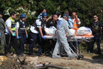 Emergency medical personnel carrying the body bag of one of three Israelis killed in a rocket attack on their apartment building in Kiryat Malachi, Nov. 15, 2012. (Moshe Milner/GPO/Flash90)