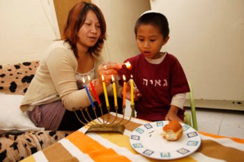 Filipinos light Chanukah candles in their home in South Tel Aviv on Nov. 24, 2010 in advance of the Jewish holiday. (Miriam Alster/FLASH90)