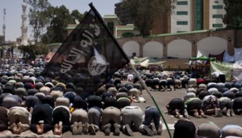 A black flag associated with Salafist Islamist movement flies in Cairo in front of supporters of former Egyptian President Mohammed Morsi during prayers the day after he was ousted from power, July 4, 2013 in Cairo, Egypt. (Photo by Ed Giles/Getty Images)