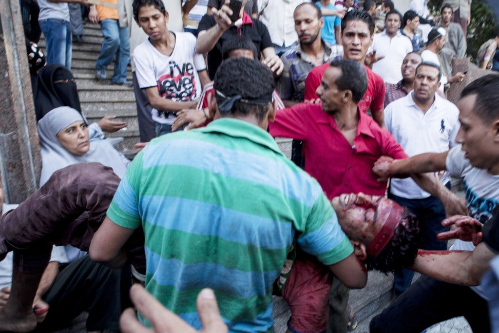 An injured supporter of deposed Egyptian President Mohamed Morsi is carried into the Fateh Mosque at Ramses Square in Cairo, Aug. 16, 2013. (Ed Giles/Getty)