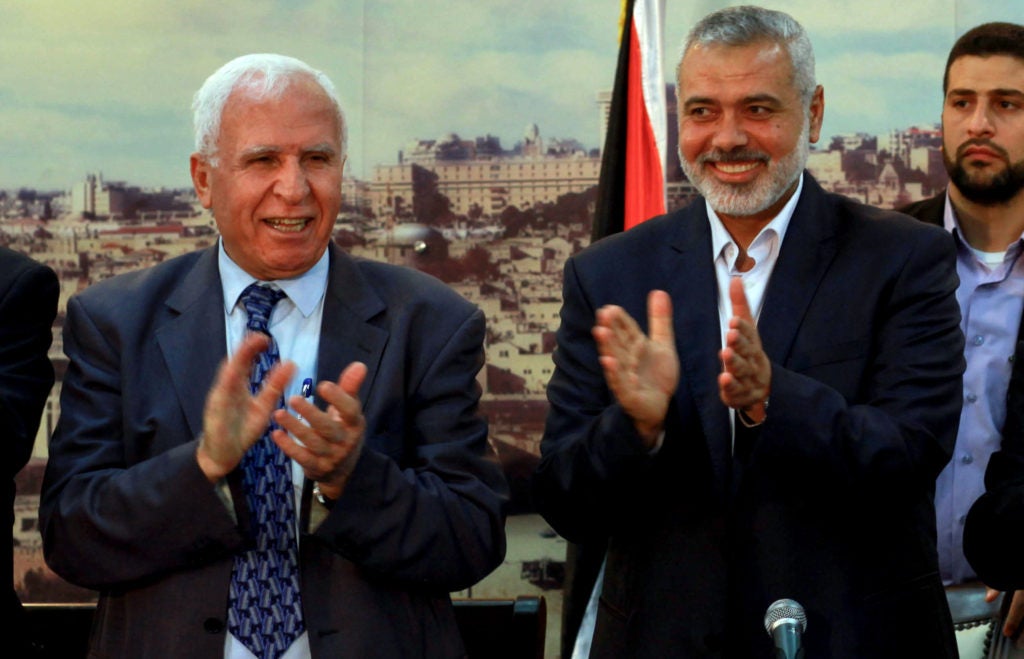 Palestinian Fatah delegation chief Azzam al-Ahmed (L) celebrates with Hamas prime minister in the Gaza Strip Ismail Haniya in Gaza City on April 23, 2014 after West Bank and Gaza Strip leaders agreed to form a unity government within five weeks. (Abed Rahim Khatib / Flash90)