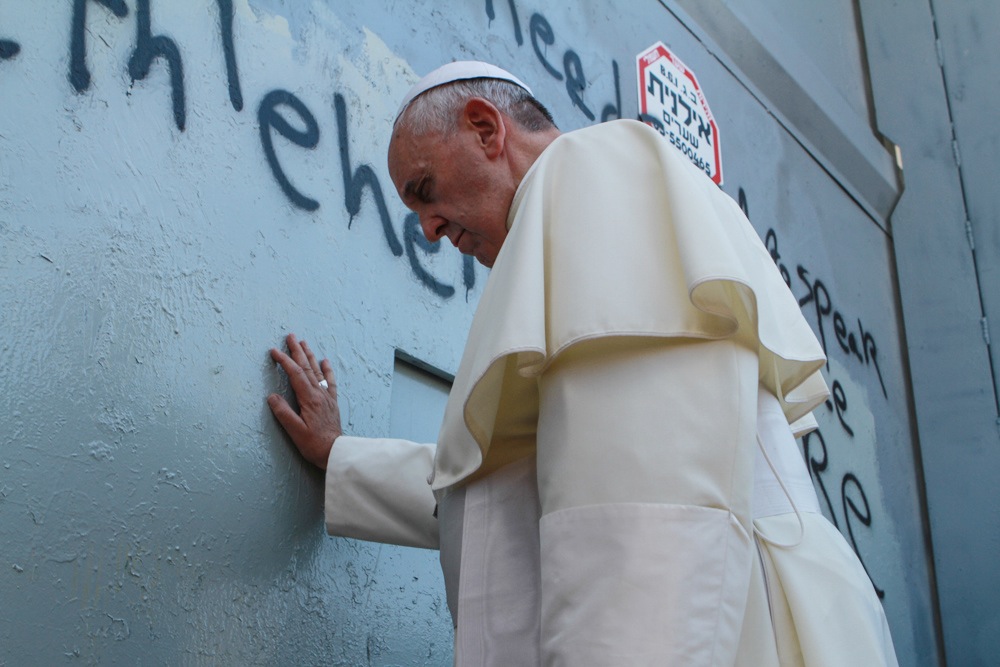 Pope Francis touching the wall that separates Israel from the West Bank on his way to celebrate a mass in Manger Square in Bethlehem, May 25, 2014. (Nour Shamaly/POOL/Flash90)