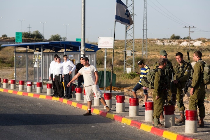 Israeli soldiers guard near where Jewish settlers hitchhike at the Gush Etzion junction in the West Bank, June 16, 2014. (FLASH90)