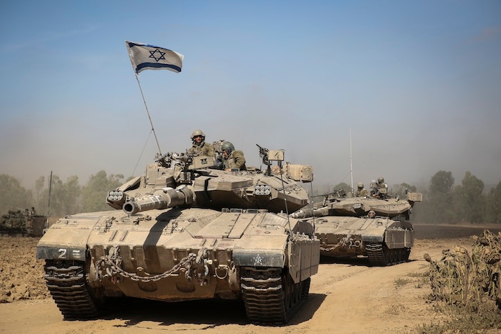 An Israeli tank crossing through a field in southern Israel near the border with Gaza, the day after Israel began its invasion of Gaza, July 18, 2014. (Hadas Parush/Flash 90)