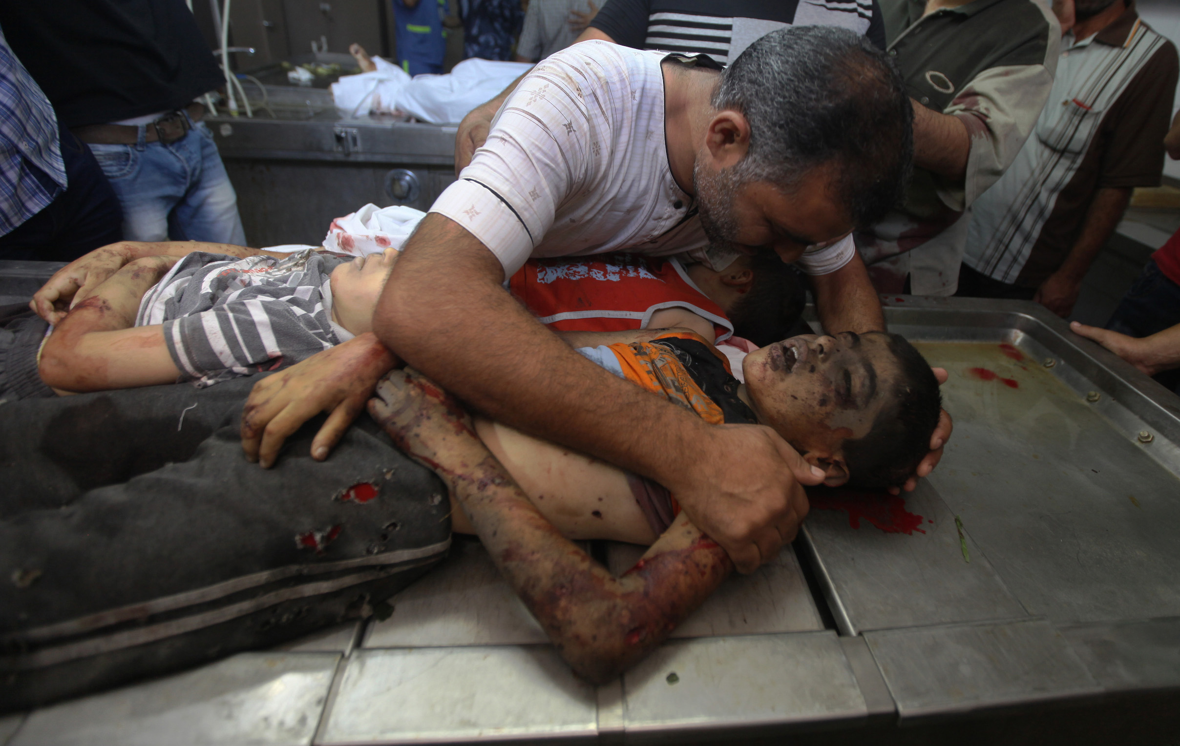 Relatives of three Palestinian boys killed by an Israeli airstrike visiting their bodies at the morgue of al-Shifa hospital in Gaza City, Aug. 21, 2014. (Emad Nassar/Flash90)