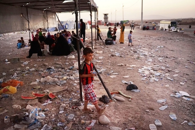 Iraqi families who fled ISIS fighters near the Iraqi city of Mosul prepare to sleep on the ground near the Khazair temporary displacement camp in a Kurdish-controlled part of Iraq, July 3, 2014. (Spencer Platt/Getty)