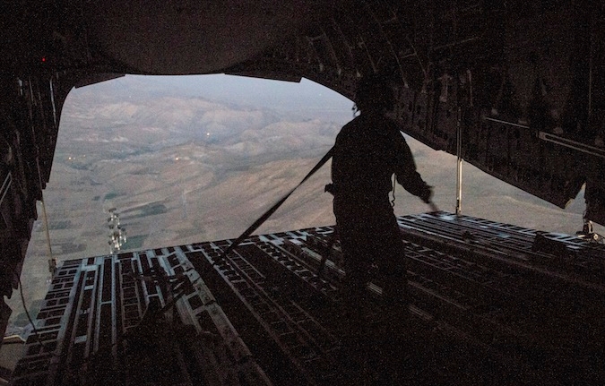 A U.S. soldier drops humanitarian aid bundles over Iraq to provide food aid to thousands of Yazidis under siege by ISIS, the group that has declared an Islamic State in Iraq and Syria, Aug. 9, 2014. (U.S. Air Force via Getty)