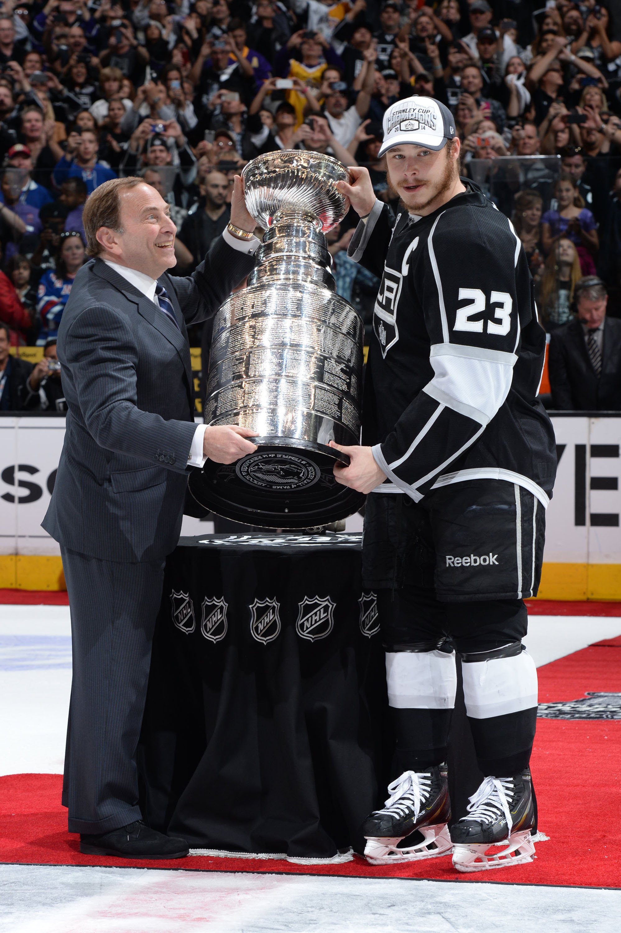 NHL Commissioner Gary Bettman, left, presenting Dustin Brown of the Los Angeles Kings with the Stanley Cup at the Staples Center in Los Angeles, June 13, 2014. (Andrew D. Bernstein/NHLI via Getty Images)