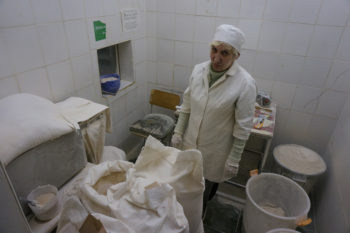 A worker surrounded by flour at the Tiferet HaMatzot factory in Dnepropetrovsk on Dec. 8, 2014. (Cnaan Liphshiz/JTA)
