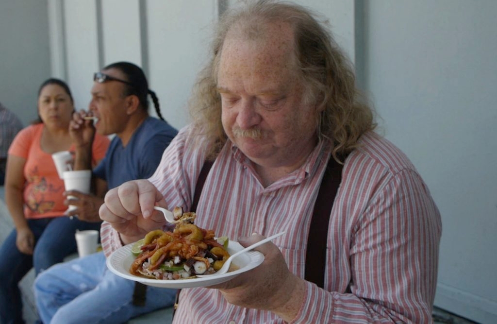Jonathan Gold digs into a Poseidon Tostada from the Mariscos Jalisco taco truck. (Courtesy of 'City of Gold')