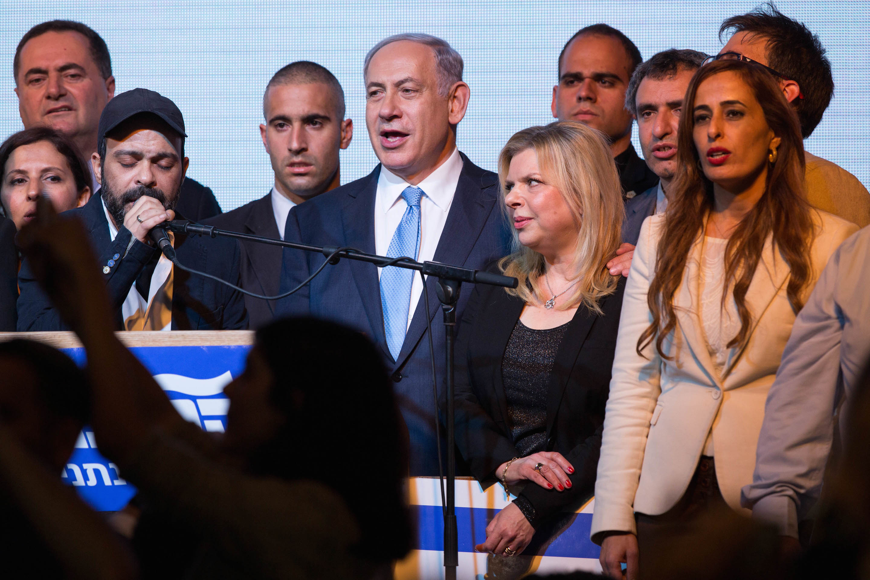 Israeli Prime Minister Benjamin Netanyahu and his wife, Sara, sing the Israeli anthem along with members of his Likud party, at the party headquarters in Tel Aviv, March 18, 2015, after the exit polls in the Israeli general elections were announced, with Netanyahu claiming victory. (Miriam Alster/FLASH90)